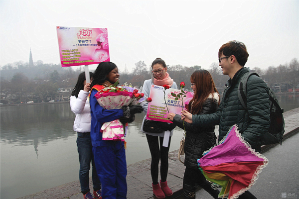 外籍女工西湖邊“關(guān)愛女工”行為體驗 游人的熱情擁抱累得她胳膊抬不起來